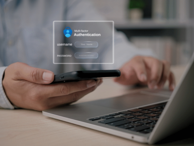 A person using a smartphone and laptop to perform multi-level authentication.